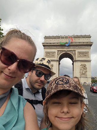 Familie vor dem Arc de Triomphe in Paris. Beliebtes Reiseziel in Frankreich für Kultur, Sightseeing und Städtereisen.