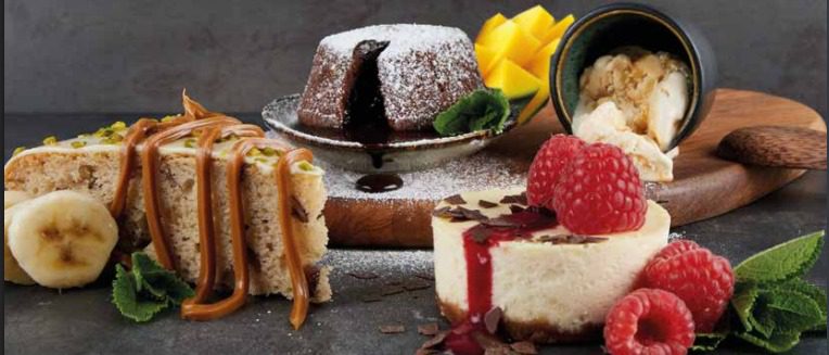 Cheesecake, Bananenkuchen und Schokoküchlein mit Himbeeren und Karamellsoße – Dessertauswahl im Lehmeier’s Eatery Neumarkt.