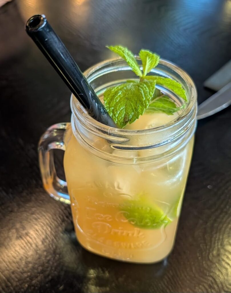 Pfirsich-Eistee mit Minze und Eiswürfeln im Glas – erfrischendes Getränk im Genji Neumarkt