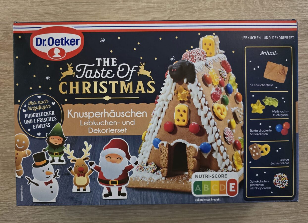 Verpackung des Dr. Oetker „The Taste of Christmas“ Lebkuchenhaus-Sets mit bunten Figuren, Lebkuchenplatten und weihnachtlicher Deko.